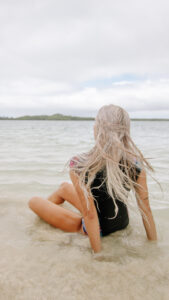 Girl sitting on the beach in the Galapagos Islands - Galapagos Islands Travel