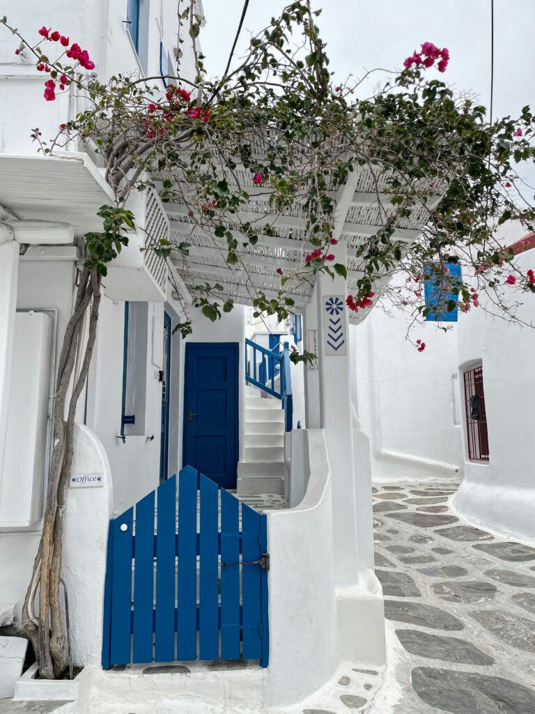 blue fence with white building in Hydra, Greece