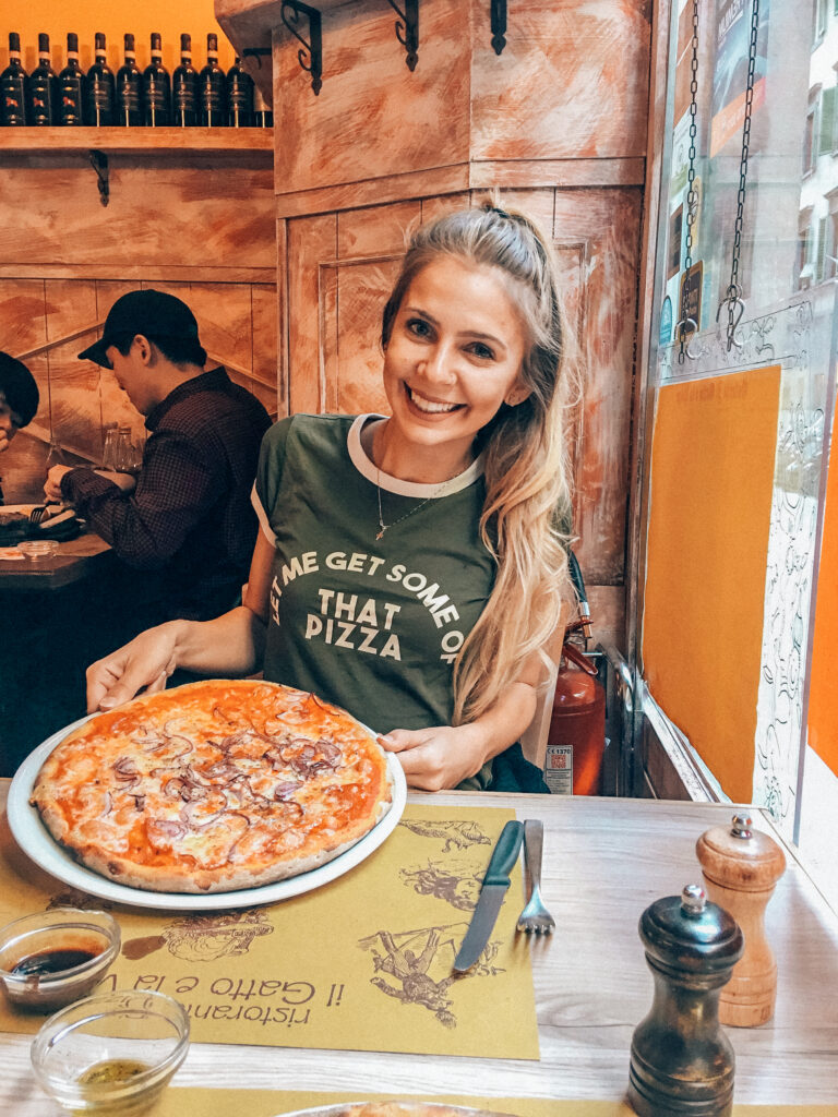 girl eating an entire pizza in florence- the boho traveller by sydney zaruba italy travel guide