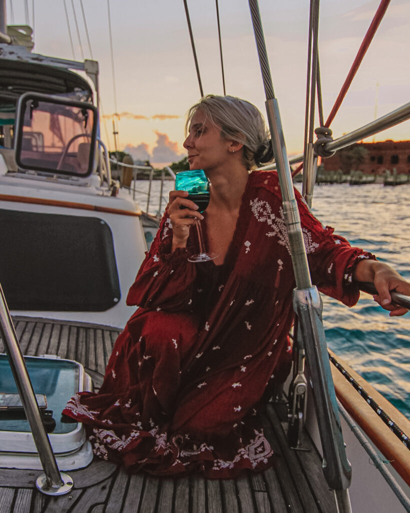 girl enjoying a glass of wine on a sunset cruise in key west florida, one of the best things to do in key west according to the boho traveller
