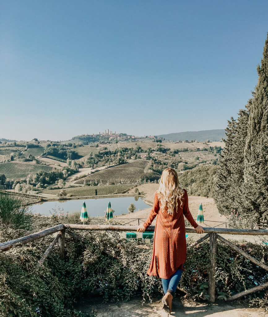 the boho traveller overlooking the medieval city of sienna and san gimignano while on a wine tasting tour in tuscany for a chianti wine tour