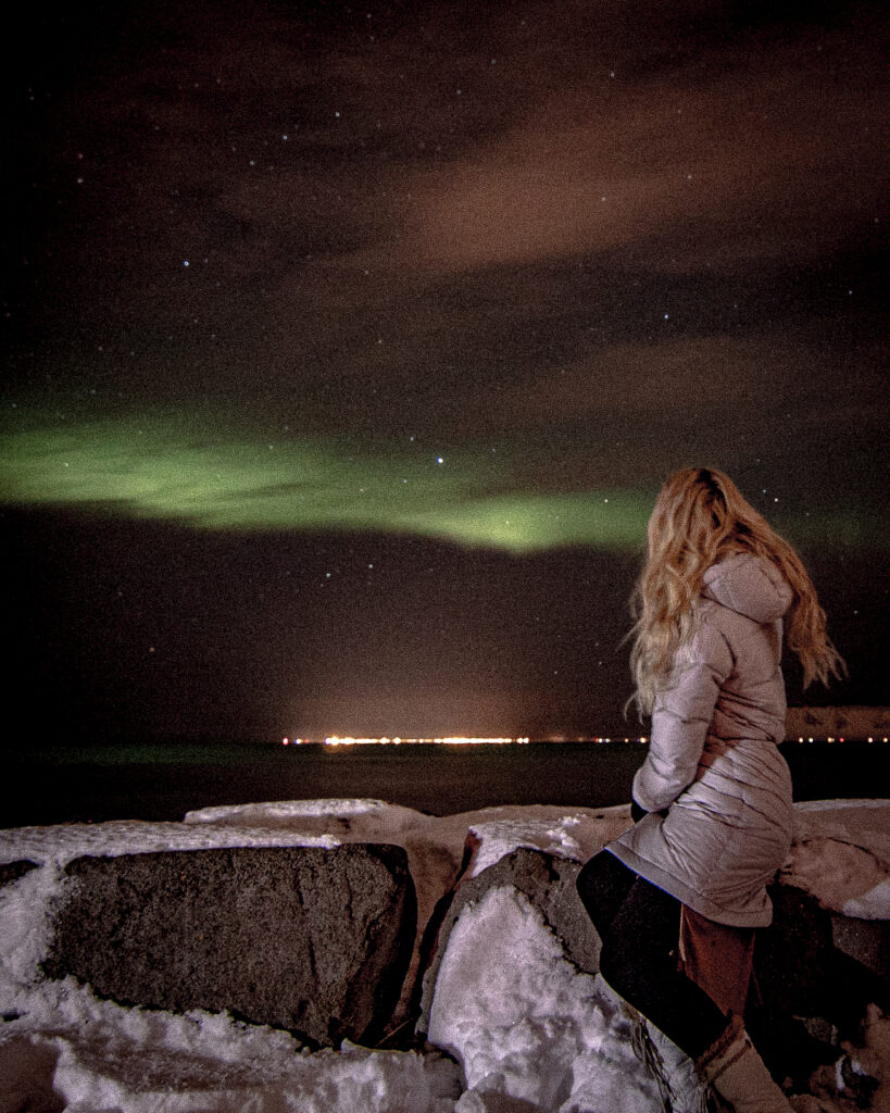Girl looking at the northern lights in Iceland. 