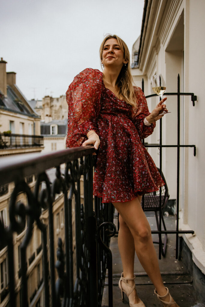 Girl on a balcony in Paris, France drinking wine. 