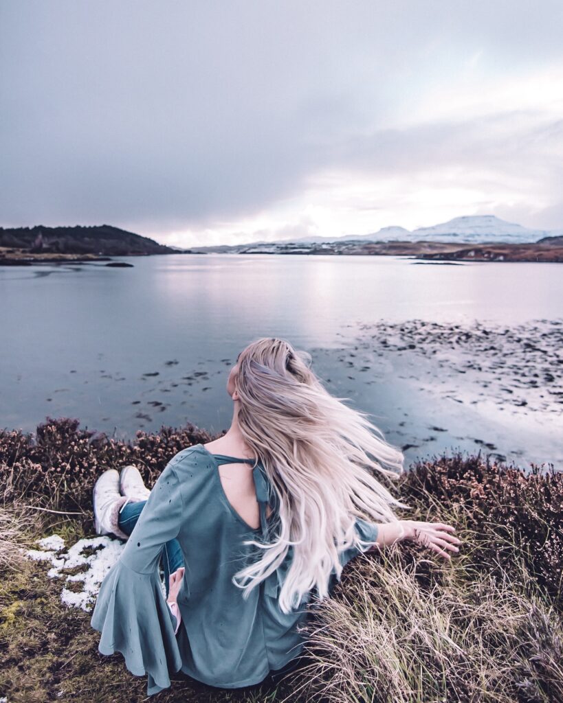 Girl looking into the water and view in Isle of Skye, Scotland. 